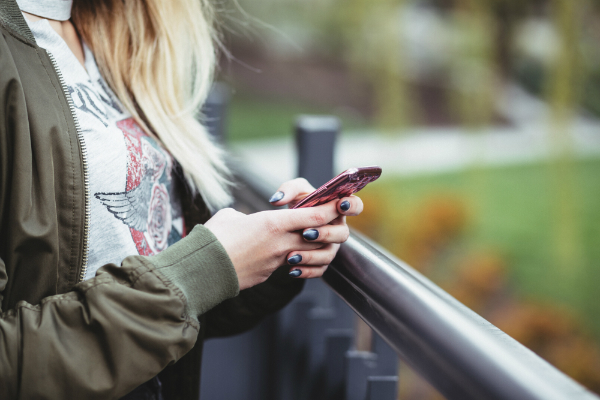 Women texting (or perhaps signing up for our app) with her red cellphone